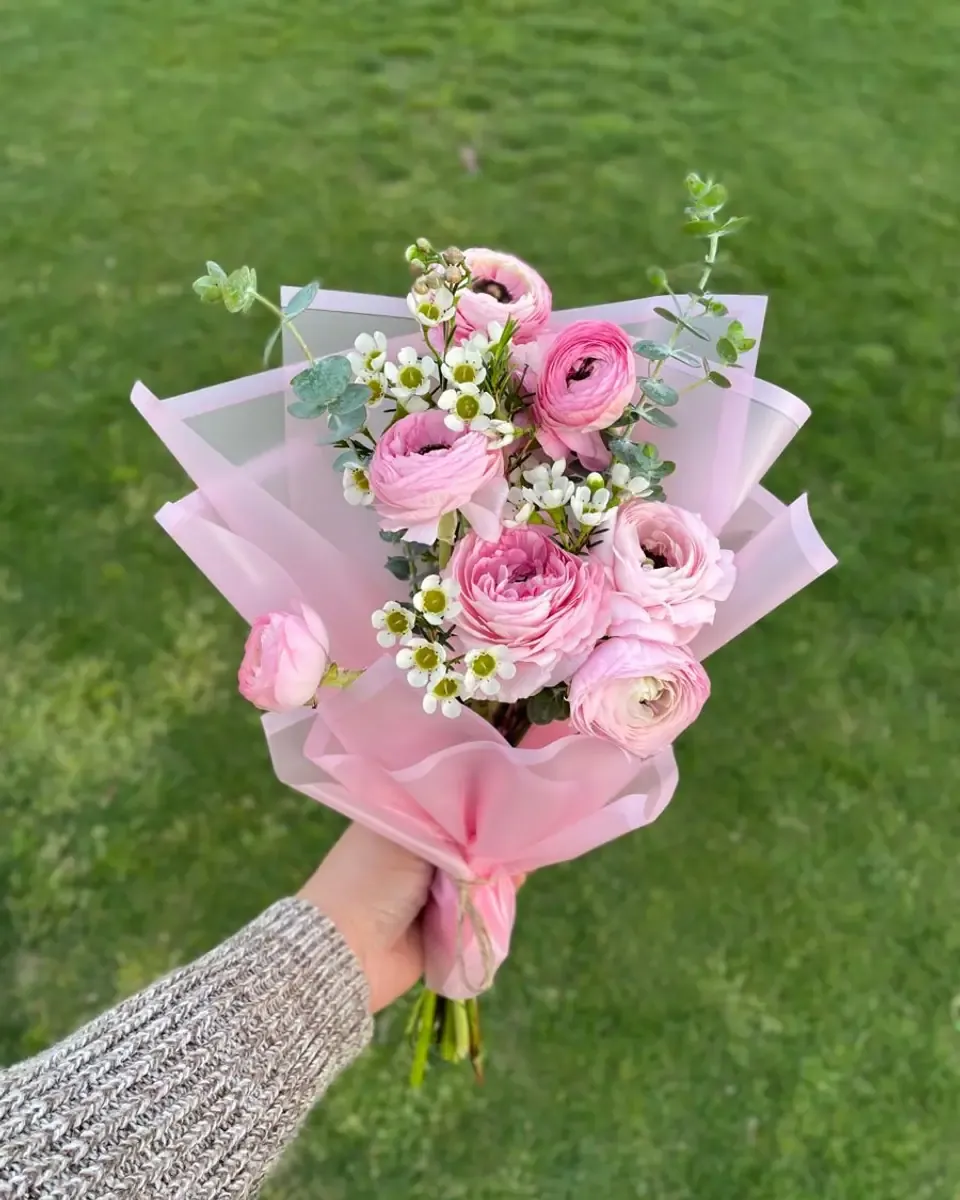 Bó nhỏ hoa mao lương hồng được cầm trên tay ngoài bãi cỏ