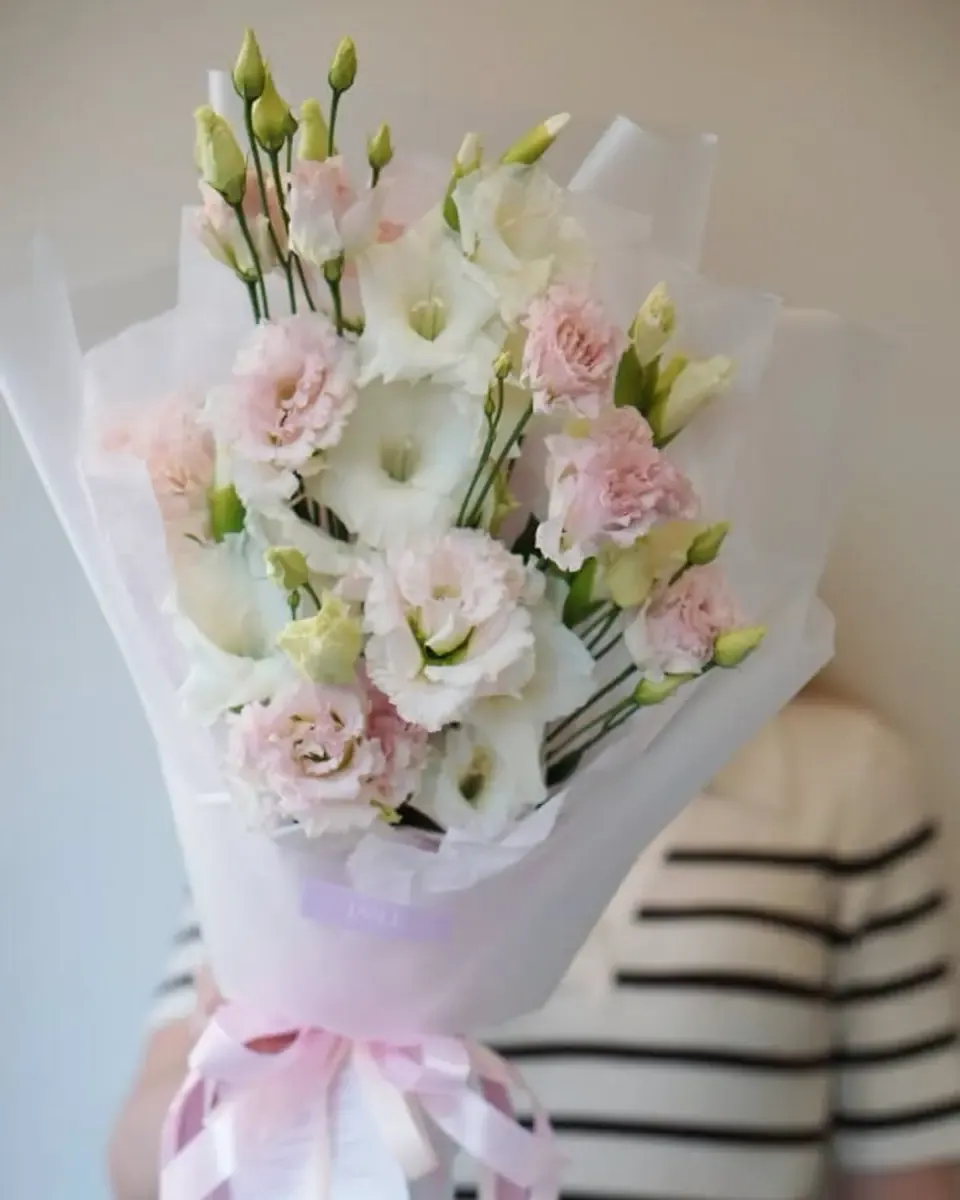 Bó lisianthus trắng hồng gói giấy kem buộc ruy băng hồng nhạt