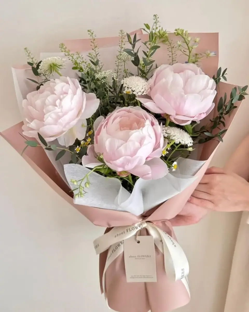 Bó mẫu đơn hồng nhạt và hoa trắng gói giấy hồng, buộc ruy băng kem