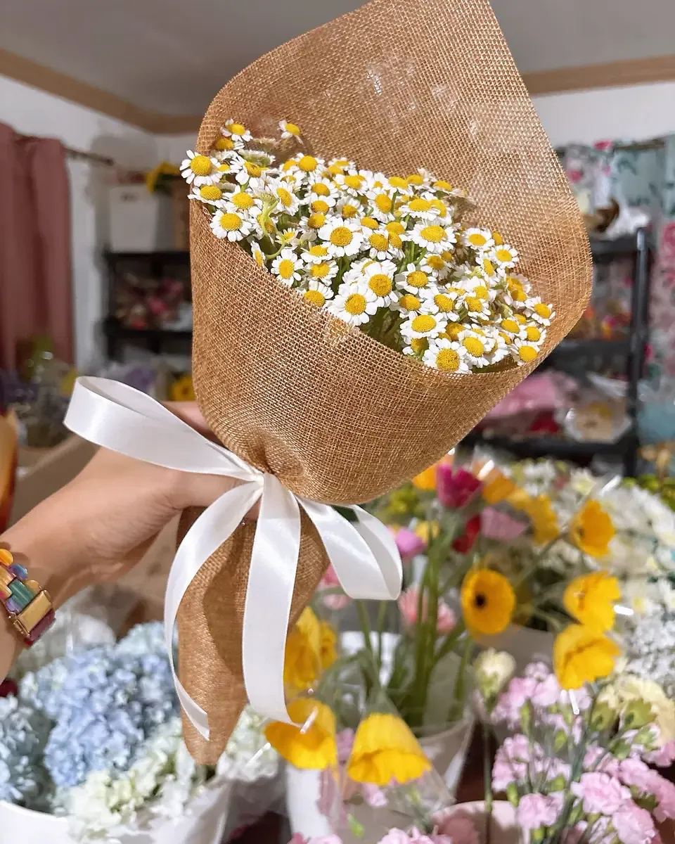 Bó cúc họa mi gói giấy bố nâu, buộc ruy băng trắng, nền cửa hàng hoa