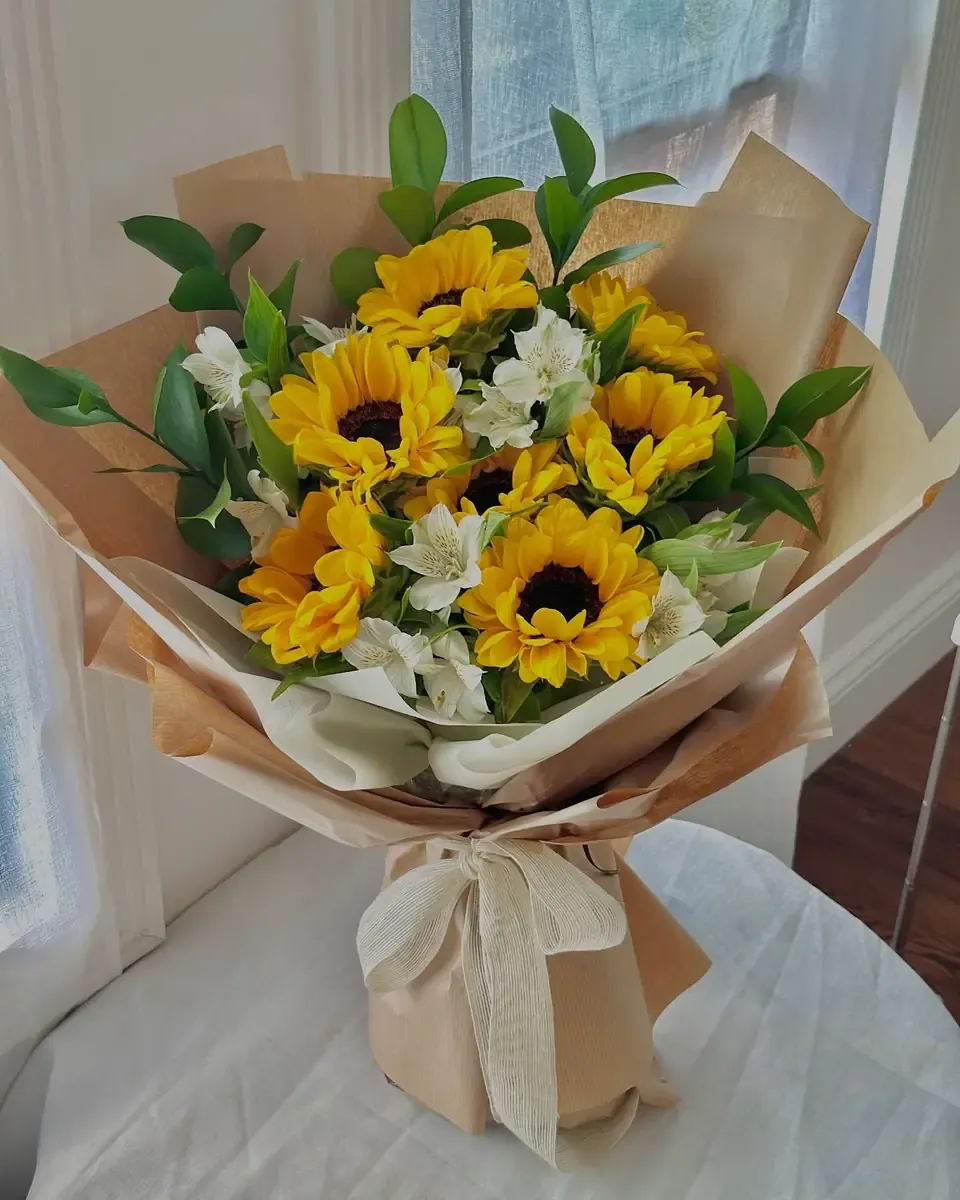 Bó hướng dương và hoa trắng nhỏ gói giấy kem và kraft, ruy băng kem