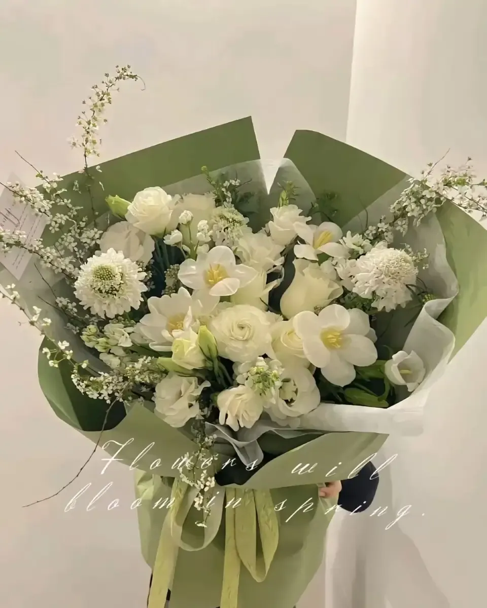 Bó hoa trắng và xanh nhạt gói giấy xanh sage, thân hoa cao, đặt trên nền sáng