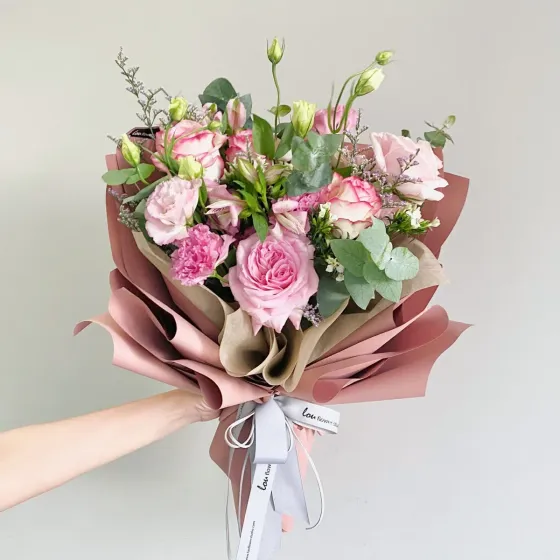 Bó hoa hồng phấn và kem trong giấy gói hồng đất