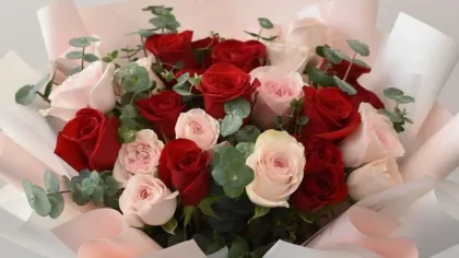 Bó hồng đỏ và hồng phấn với lá bạch đàn, giấy gói trắng hồng, ruy băng nâu hồng